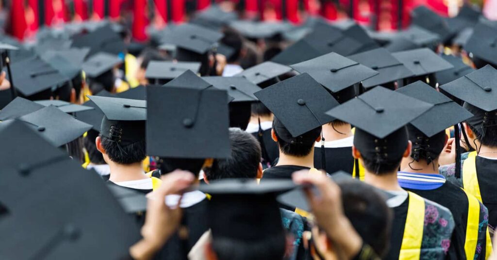 Group of students in graduation caps from behind.