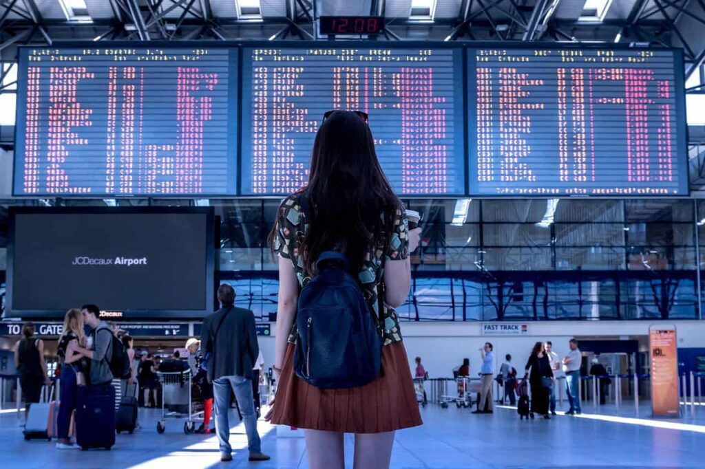 Woman looking at travel board in airport.