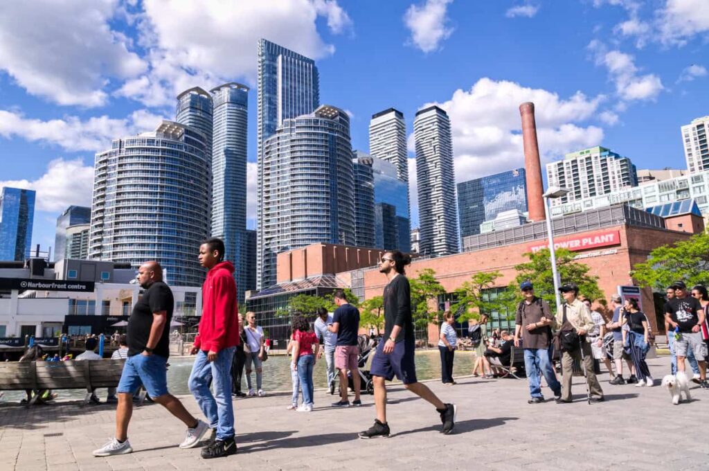 People walking in front of Toronto skyline.