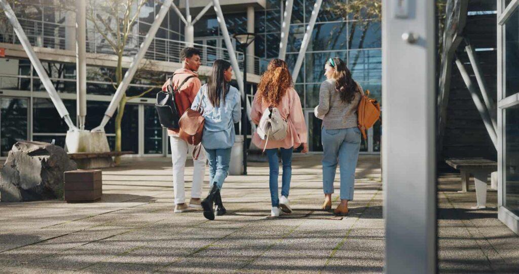 College students walking and chatting from behind.